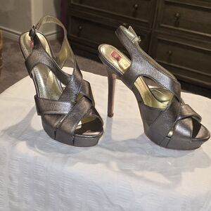 Grey high heel shoes with a cross in the front, size 7.5